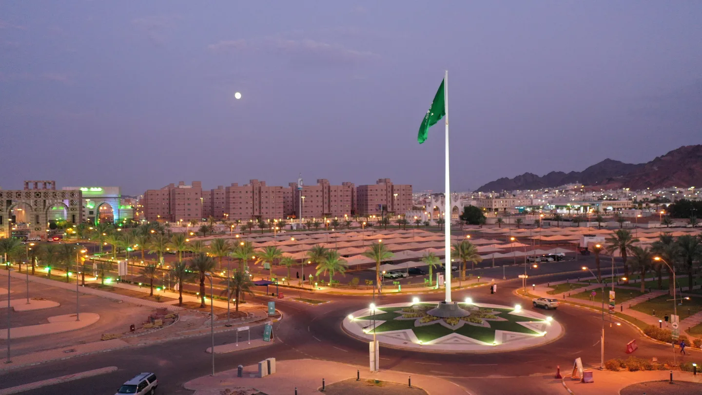 العلم السعودي وممرات الجامعة عند الغروب
